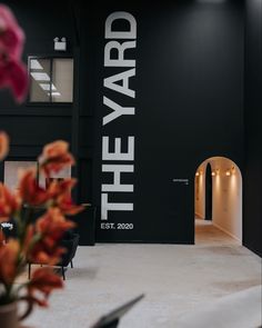 a black and white sign that says the yard estt 2020 in front of some flowers