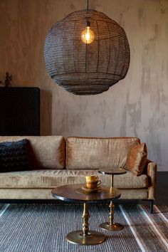 a living room with a couch, coffee table and lamp hanging from it's ceiling