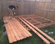 a man working on building a wooden deck