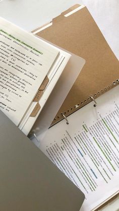 two binders and some papers on top of a desk