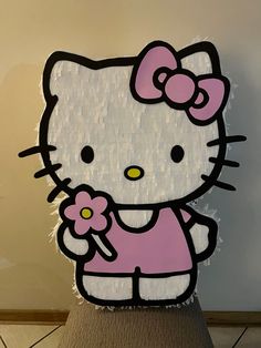 a hello kitty cut out on top of a piece of wood with a flower in it