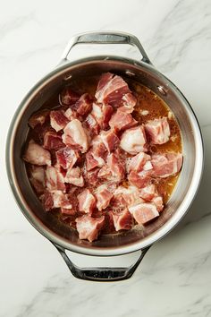 the meat is being cooked in the pot