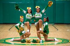 three cheerleaders pose on the basketball court