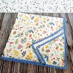 two napkins sitting on top of a wooden table next to a white doily