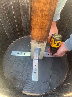 a person using a drill to attach a piece of wood