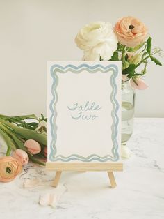 a table with flowers and a sign on it