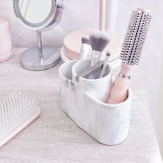 there are two brushes in the cup on the table next to the brush and comb