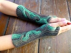 a woman's hand is shown with green knitted fingerless gloves