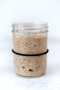 a glass jar filled with food sitting on top of a white counter next to a black rubber band