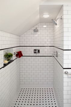 a white tiled bathroom with black and white tile