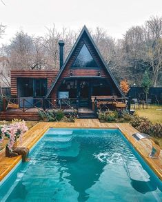 a house with a pool in front of it and a deck on the other side