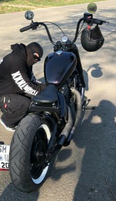 a man sitting on top of a black motorcycle