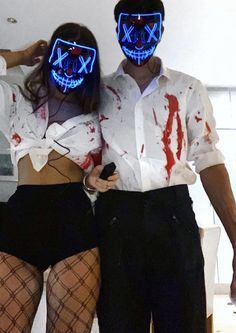 two people wearing neon masks standing next to each other with blood all over their body