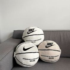 three nike basketballs sitting on top of a couch