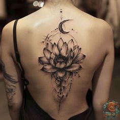 a woman's back with a lotus tattoo on it