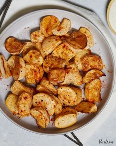 a white plate topped with sliced potatoes on top of a table