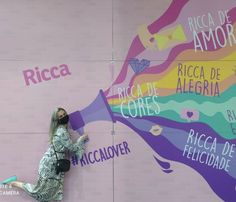 a woman leaning up against a wall with words painted on it