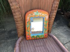 a wicker chair with a mirror on it