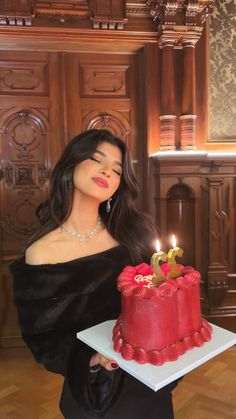 a woman holding a cake with candles on it