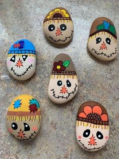 six painted rocks with different faces on them