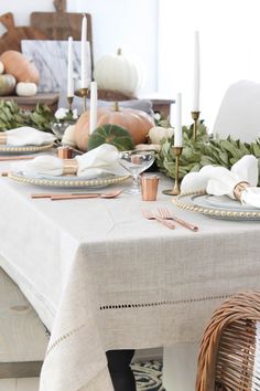 the table is set with candles, plates and napkins