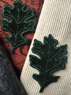 three different types of knits with green and red designs on them, including one leaf