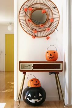 two pumpkins sitting on top of a table in front of a mirror and record player