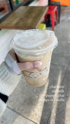 a person holding a cup of coffee in their left hand with the caption that says, chai latte oatmilk 3 pumps chat puppies at vanilla