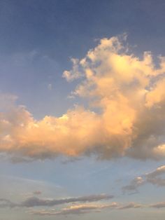 the sky is filled with clouds and there are sheep grazing in the field below it