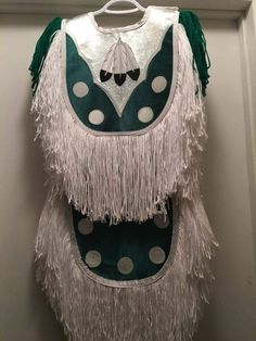 a green and white costume hanging on a wall