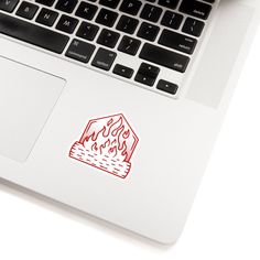 a laptop computer sitting on top of a desk with a red sticker on the keyboard