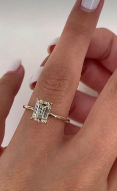 a woman's hand with a ring on it and a diamond in the middle