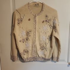 This Was Handed Down To Me From A Family Member Who Wore It In The 50s, So It Is Vintage The Embroidery Work Is Unbelievable- Not One Piece Of Embroidery Is Missing! But There Are Flaws, Holes From Age. I Have Tried To Show Them In The Pics. I Have Worn It With The Flaws, And They Are Not Noticeable, But Someone Could Get Them Repaired I Have Been Told. It's A Cream Color, Has A Mesh Lining No Pearl Buttons Missing! All Intact I Am Firm On The Price Because Of The Amazing Embroidery On It And How Pristine The Embroidery Condition Is I'm Guessing On The Size Because They Didn't Put Sizes Back Then, So I Would Say It Is A Small. There Are Also Two Very Small Dots On It. Hard To See, Vintage Cream Sweater With Floral Embroidery, White Vintage Cardigan With Floral Embroidery, Vintage Floral Embroidered Long Sleeve Cardigan, Vintage Embroidered Cream Cardigan, Vintage Cream Embroidered Cardigan, Vintage Winter Sweater With Floral Embroidery, Fitted Cream Sweater With Floral Embroidery, Beige Fitted Retro Cardigan, Vintage Embroidered Fall Sweater