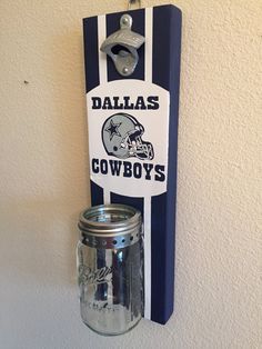 a wall mounted mason jar holder with the word cowboys on it