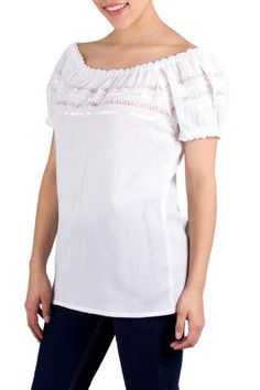 By Judith de Cuellar this charming peasant-style blouse features a scoop neck and puffed sleeves. White crinkled cotton is richly adorned with ribbons and deshilado or Spanish cutwork for feminine elegance. The blouse can be worn on or off the shoulders. Cotton Peasant Top With Puff Gathered Sleeves, Fitted Peasant Top With Gathered Sleeves For Summer, Cotton Smocked Top With Gathered Sleeves, Spring Cotton Peasant Top With Square Neck, Fitted Cotton Peasant Top With Ruffles, Cotton Peasant Top With Smocked Bodice And Puff Sleeves, Cotton Smocked Top With Gathered Sleeves And Square Neck, Feminine Peasant Top With Puff And Gathered Sleeves, Feminine Peasant Top With Puff Sleeves