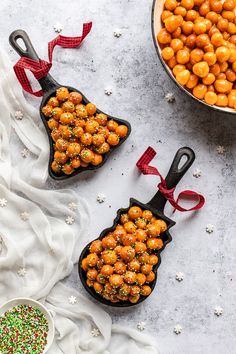 two black serving spoons filled with chickpeas next to a bowl of christmas sprinkles