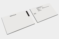 two white business cards on top of each other with black and white ink in the middle