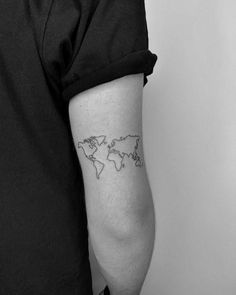 a black and white photo of a person with a world map tattoo on their arm