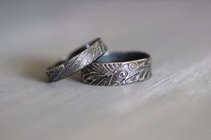 two wedding rings sitting next to each other on a table