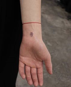 a person's hand with a small tattoo on it