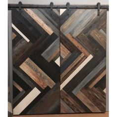 a pair of sliding doors made out of wood and metal bars with geometric designs on them