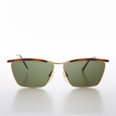 This elegant sunglasses feature an embossed brow bar and gold frame with green lenses. Prescription friendly frame. New old stock. Never worn. Great condition. UV protection. NOS deadstock Made in Korea FIT INFORMATION 53mm Eye Size 20mm Bridge 140mm Temple/Arm Width 5 1/2 Inches Height 1 3/4 Inches Shop more Vintage Sunglasses @ https://www.etsy.com/shop/SunglassMuseum Shop more Vintage Reading Glasses @ https://www.etsy.com/shop/RetroVintageReaders Gold Retro Sunglasses With Mirrored Lenses, Retro Gold Sunglasses With Mirrored Lenses, Vintage Gold Sunglasses With Polarized Lenses, Vintage Square Frame Metal Sunglasses, Vintage Gold Sunglasses With Gradient Lenses, Vintage Gold Sunglasses For Summer, Gold Retro Aviator Sunglasses With Gradient Lenses, Retro Gold Aviator Sunglasses With Mirrored Lenses, Retro Gold Aviator Sunglasses With Gradient Lenses