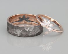 two wedding bands with flowers and leaves on them, one in gold and the other in silver