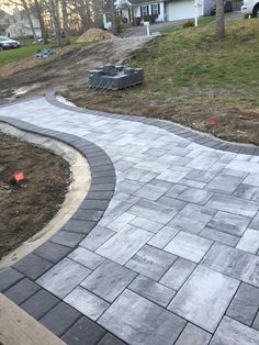 an outdoor walkway made out of pavers and brick in the middle of a yard