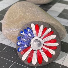 an american flag painted rock sitting on top of a black and white checkered floor