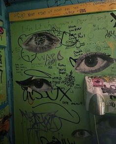 graffiti on the wall next to a toilet paper dispenser