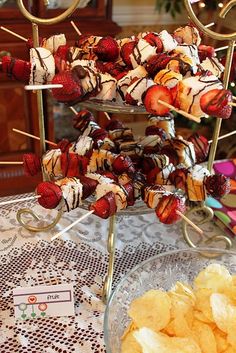 strawberries and chocolate covered marshmallows are on a platter with skewers