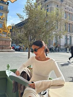 a woman sitting at a table in front of a building