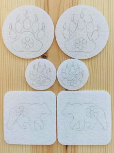 four coasters that have been cut out to look like bears and paw prints on them