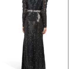 a woman in a long black dress with sequins on it